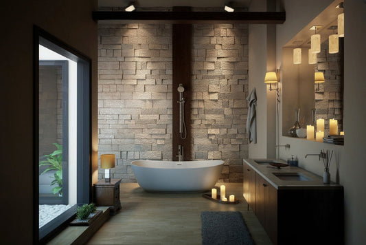 Modern bathroom with freestanding bathtub, stacked stone feature wall, vanity sink, and warm ambient lighting