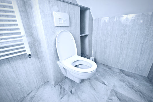 Wall-hung WC in a modern bathroom with grey stone-look tiles and concealed cistern.